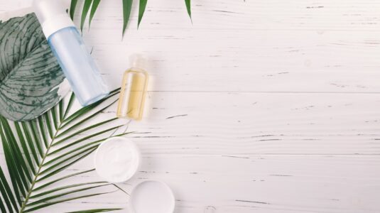 top-view-tropical-leaves-with-beauty-tools-cosmetics